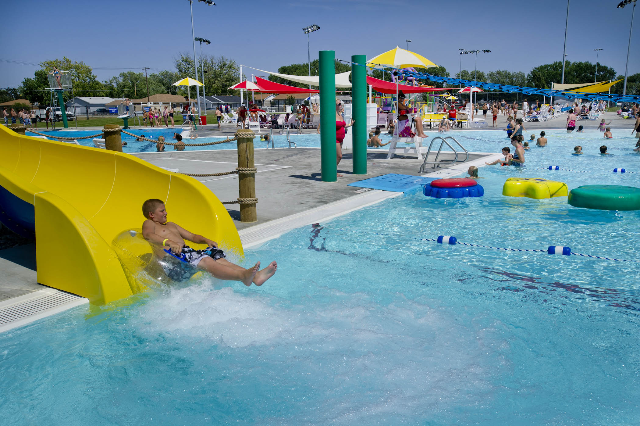 A child riding on an inner tube splashes into the pool at the end of a slide at a water park in Nebraska.