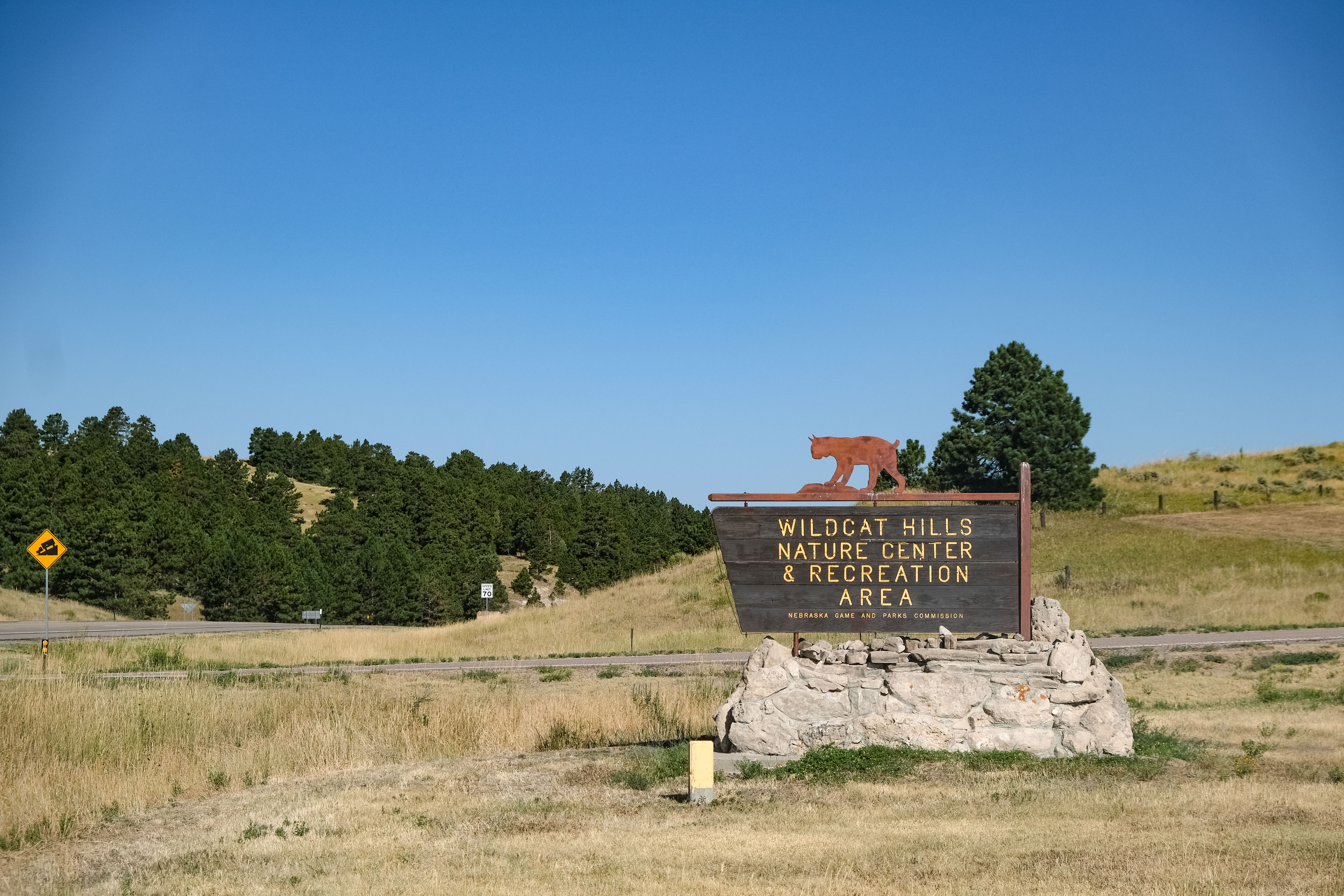 A sign for Wildcat Hills State Recreation Area with wide-open spaces and scenic vistas in the background