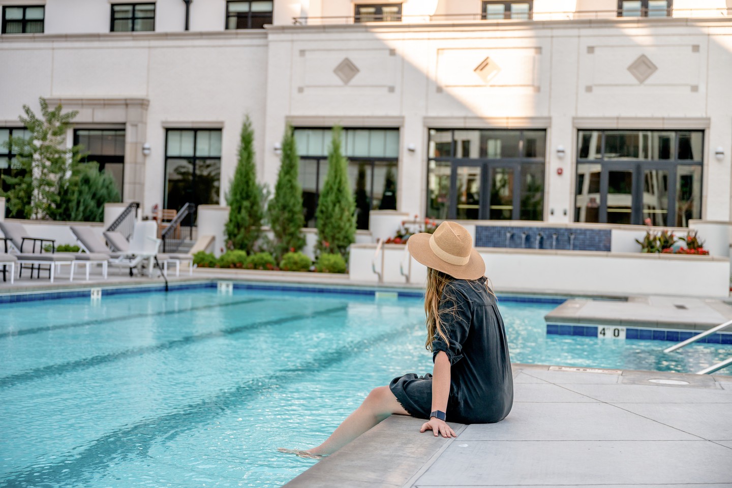 A woman sits by the pool at Kimpton Cottonwood Hotel in Omaha.