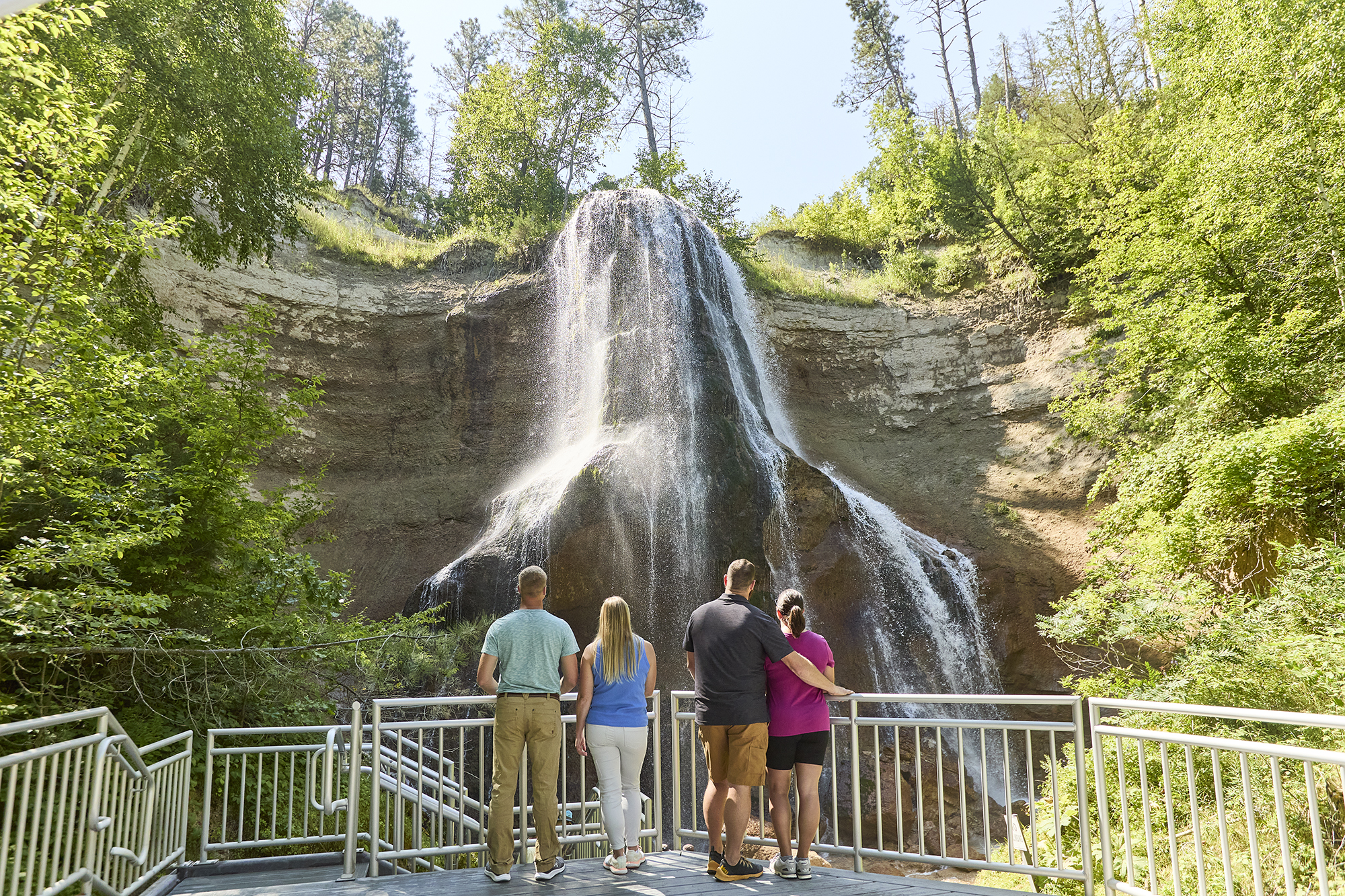 Four people watch the falls at Smith Falls State Park, home to the state's largest waterfall.