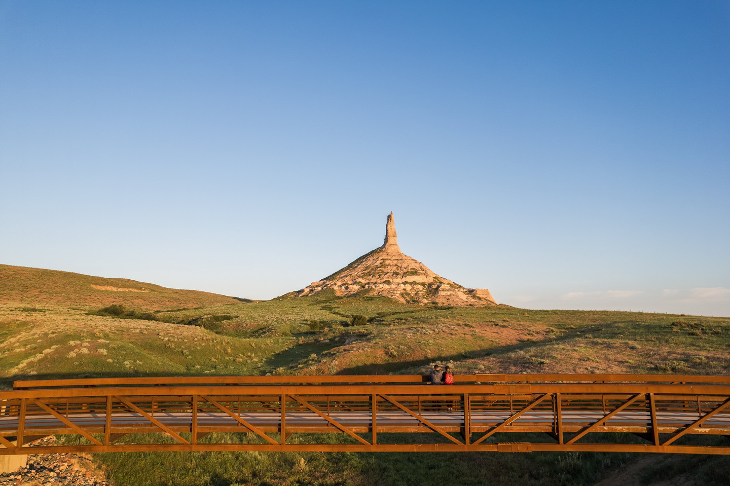A couple on a bridge admiring Chimney Rock.