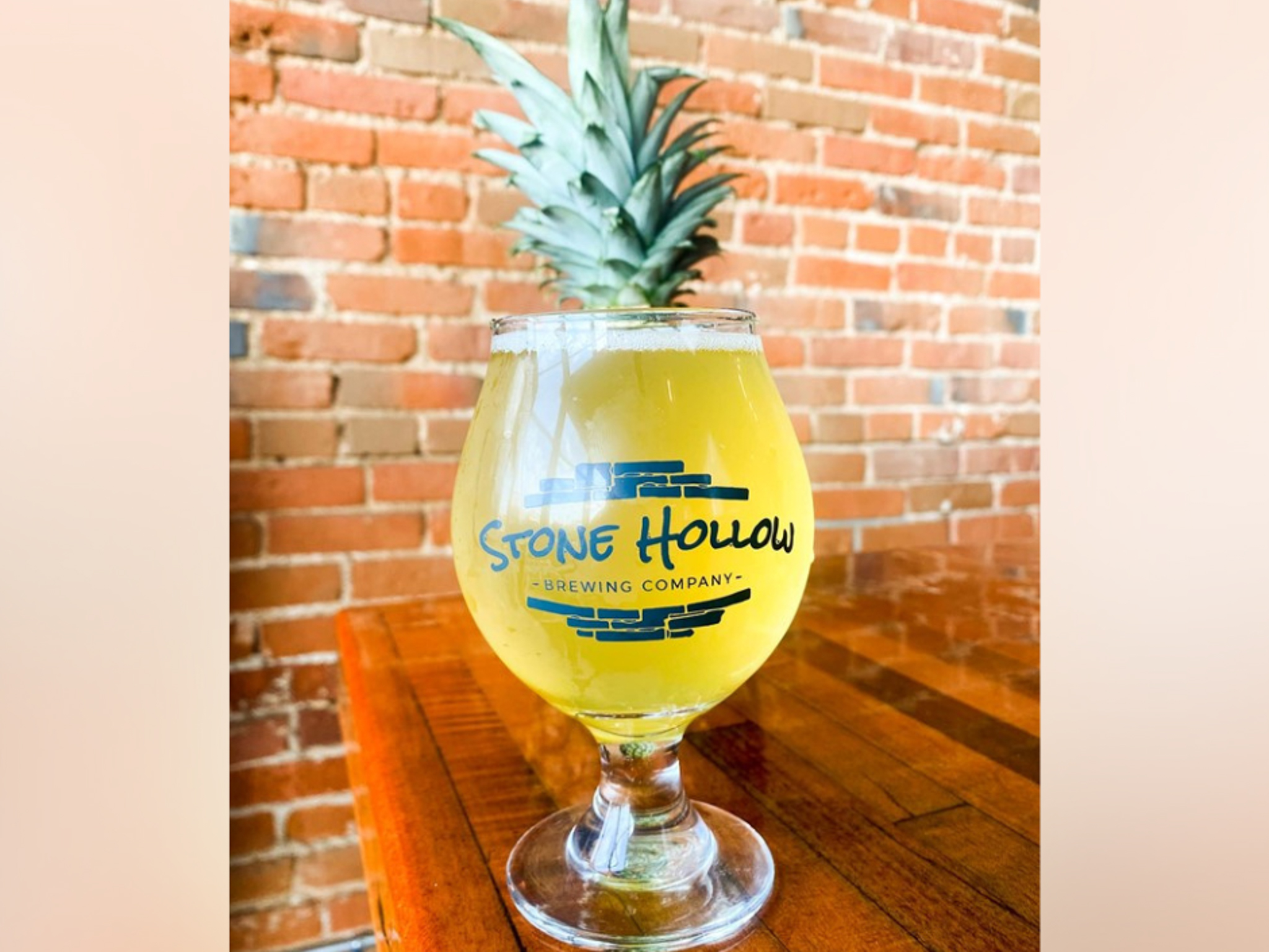 A glass of cider on a bar at Stone Hollow Brewing.