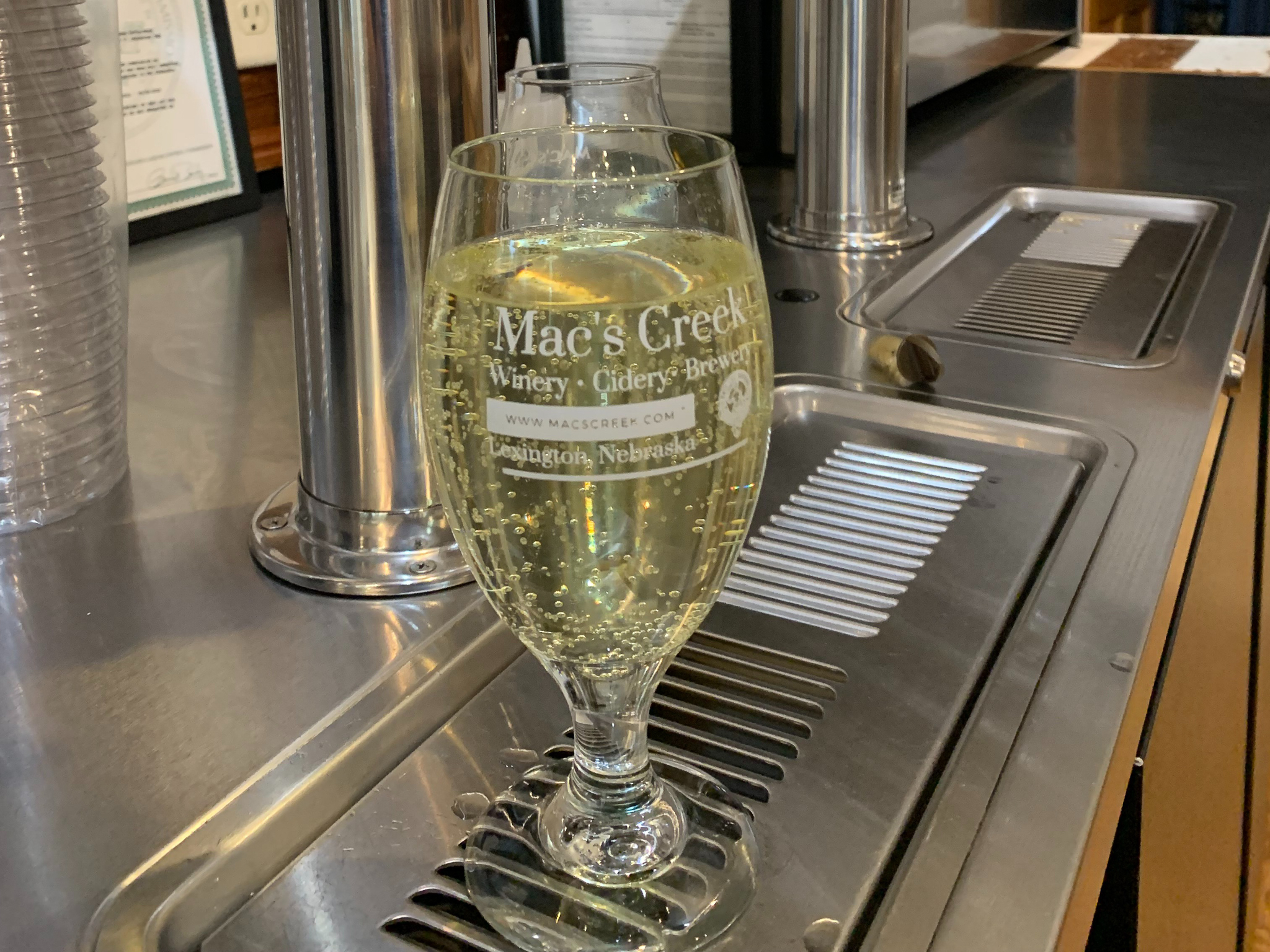 Glass of a bubbling craft beverage at Mac's Creek Winery.