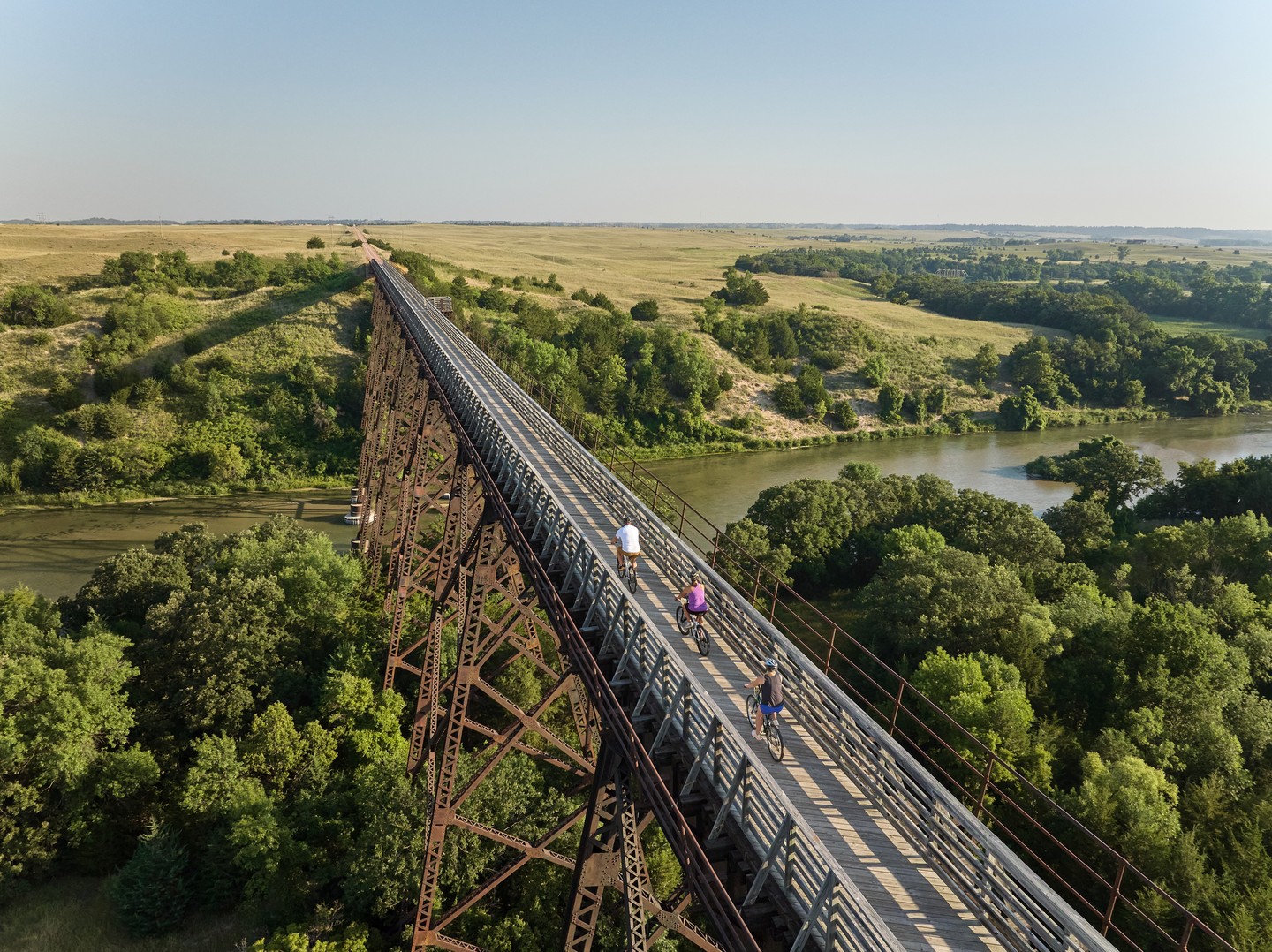 Cyclists on a large bridge along the Cowboy Trail.