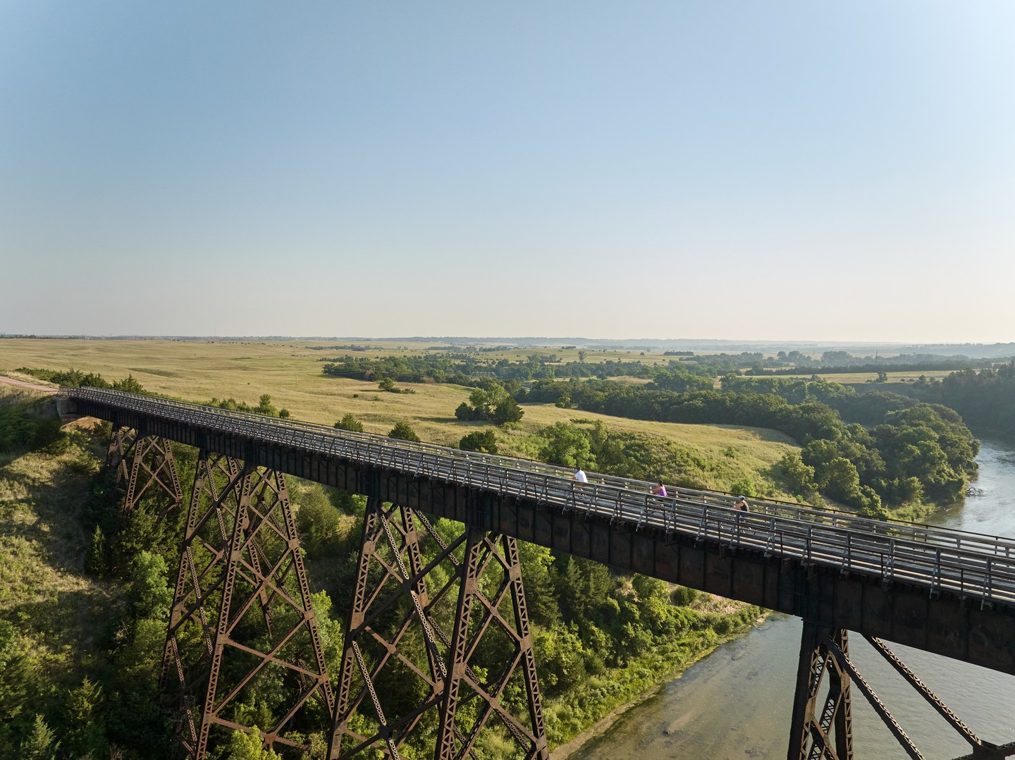 Bikers on a large bridge over a river on the Cowboy Trail near Valentine.