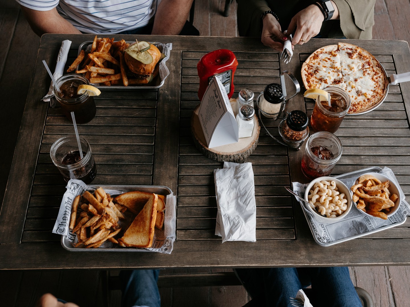 A table with fries and sandwich trays and cold sodas at Driftwood.