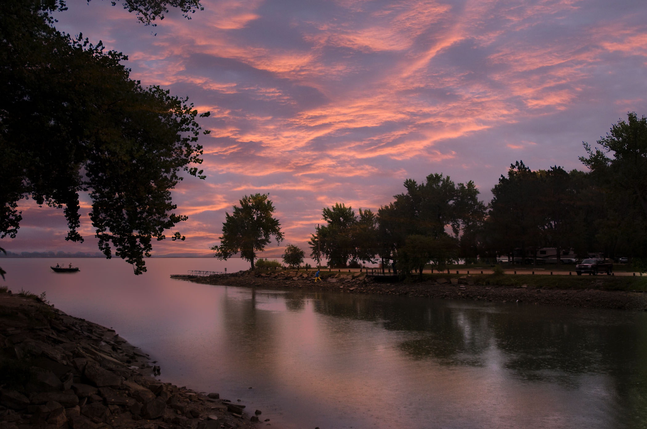 Johnson Lake under a pink and blue sky at sunset with a fishing boat on the water.