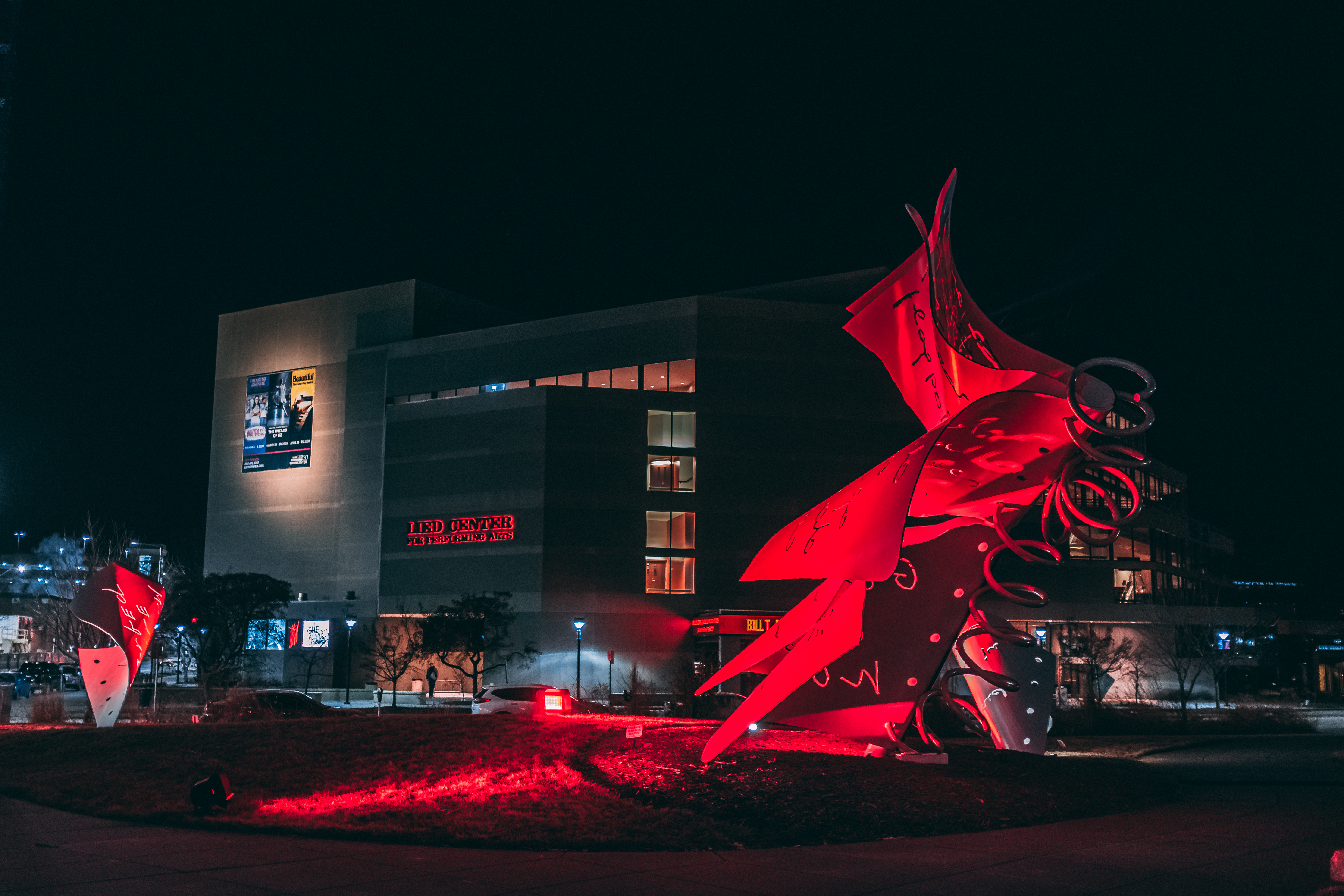 The exterior of Lied Center for Performing Arts with the sign illuminated in red.