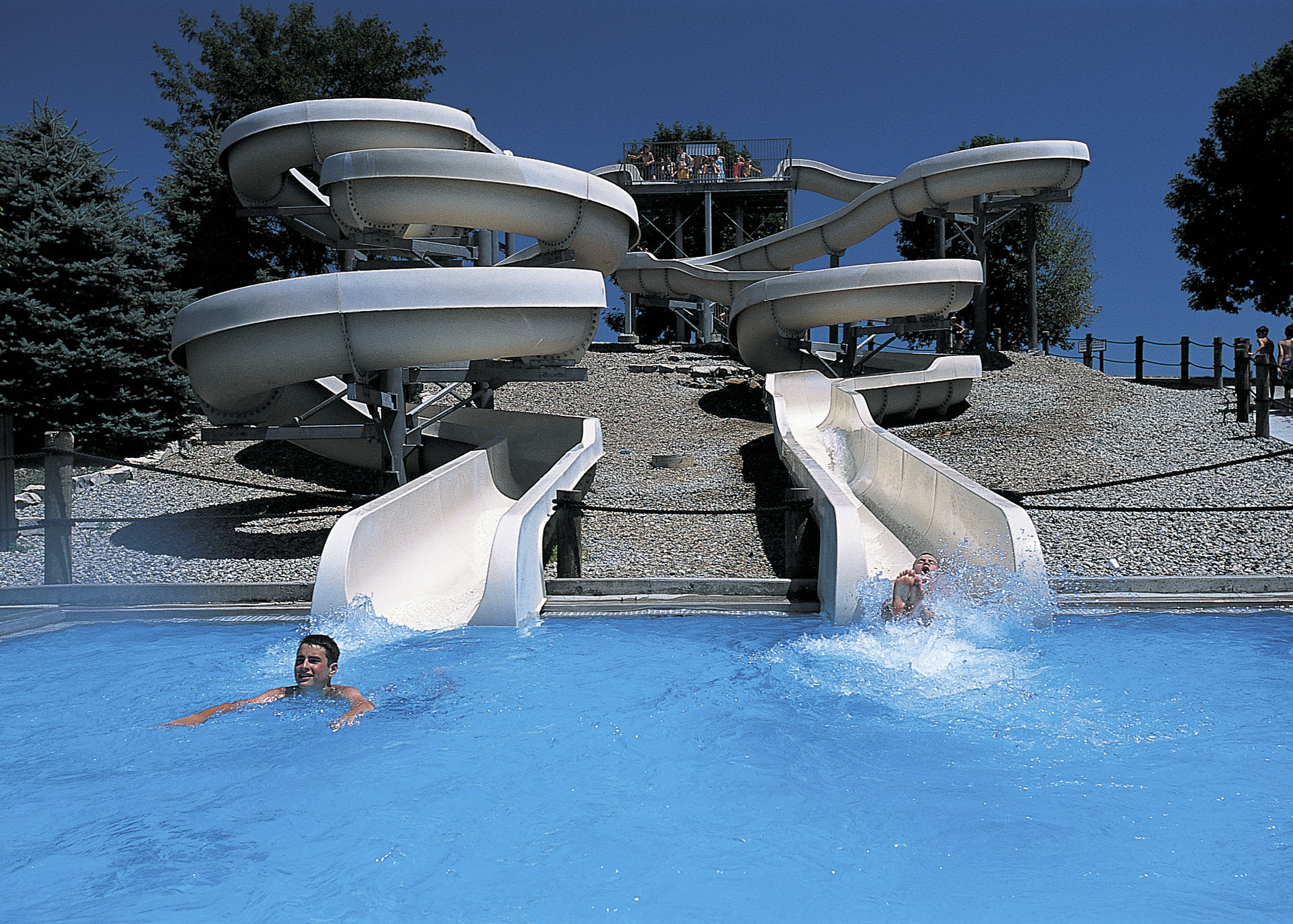 Two people sliding down twin waterslides at Eugene T. Mahoney State Park's Family Aquatic Center.