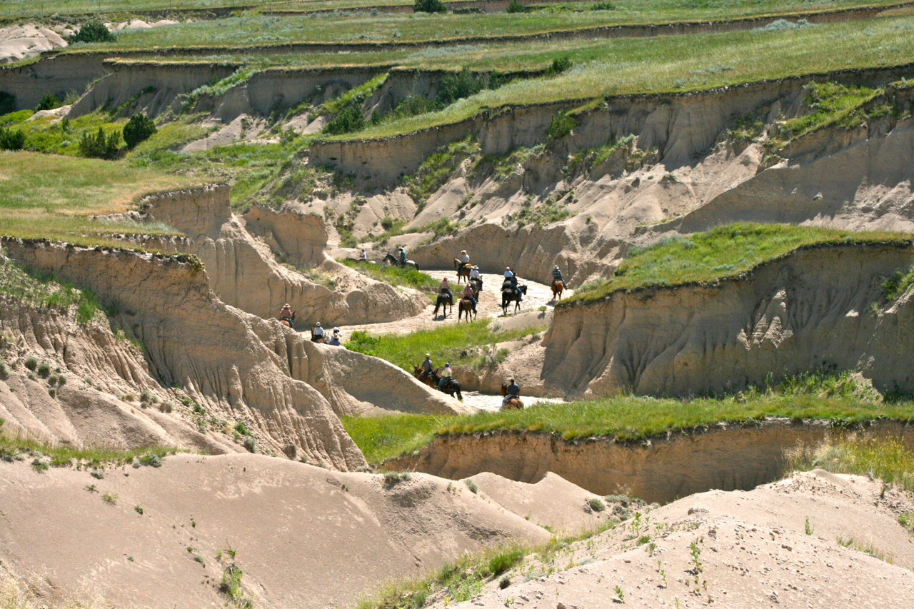 Folks horseback riding along trails at Our Heritage Guest Ranch.