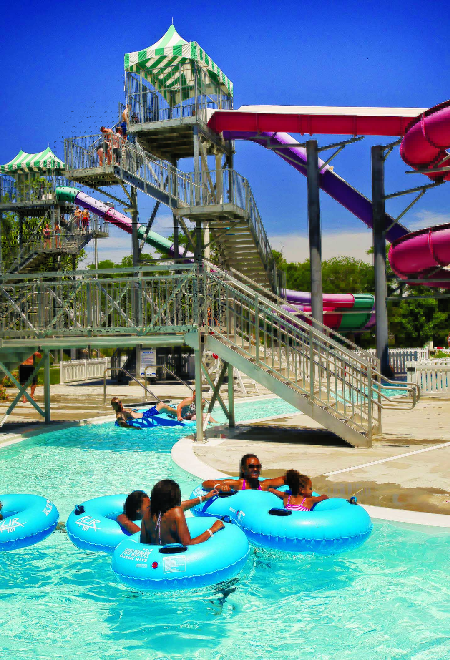 People stand in short lines to whiz down brightly colored water slides at Pawnee Plunge in Columbus, Nebraska.