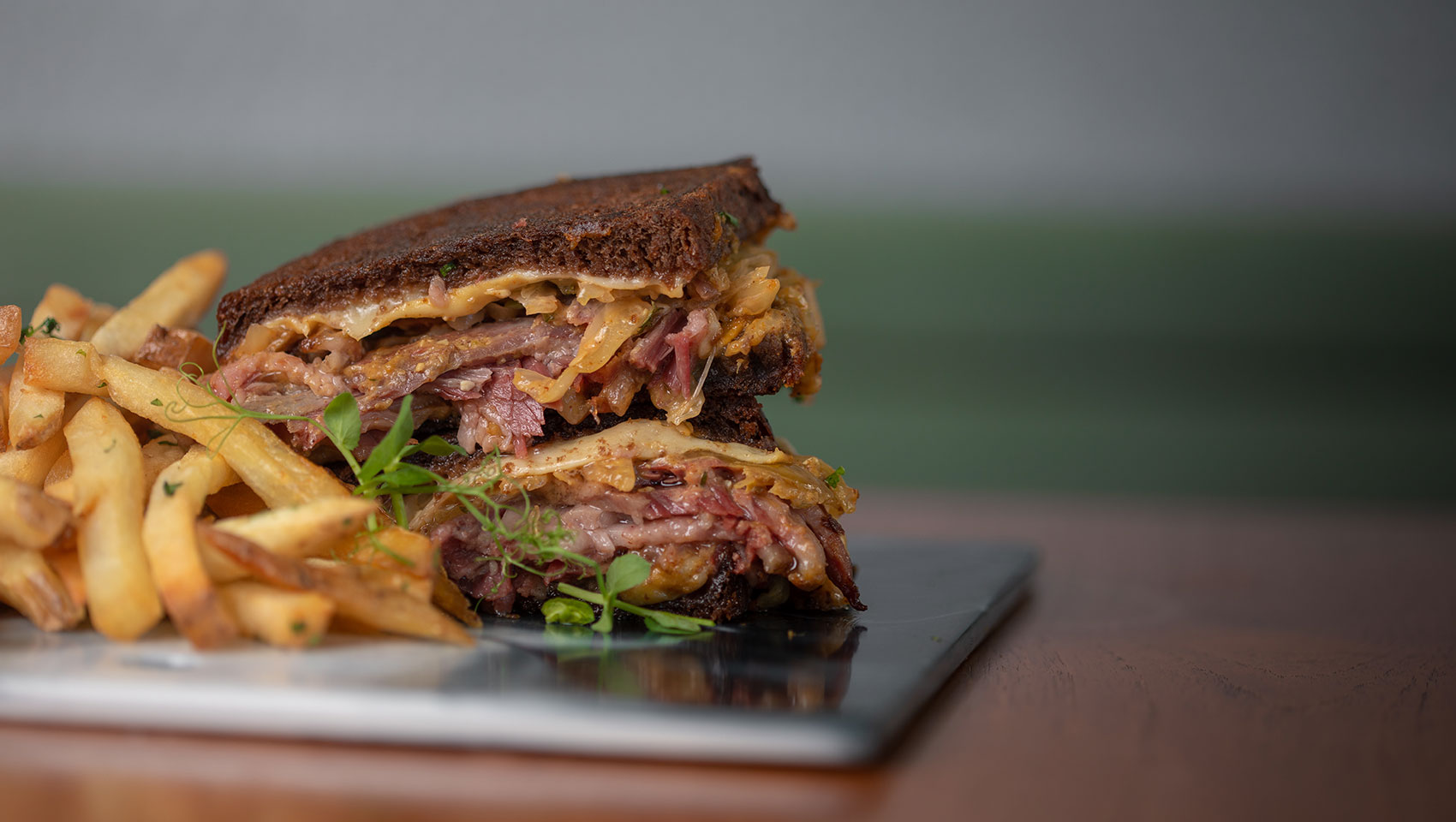 A Reuben Sandwich with fries.