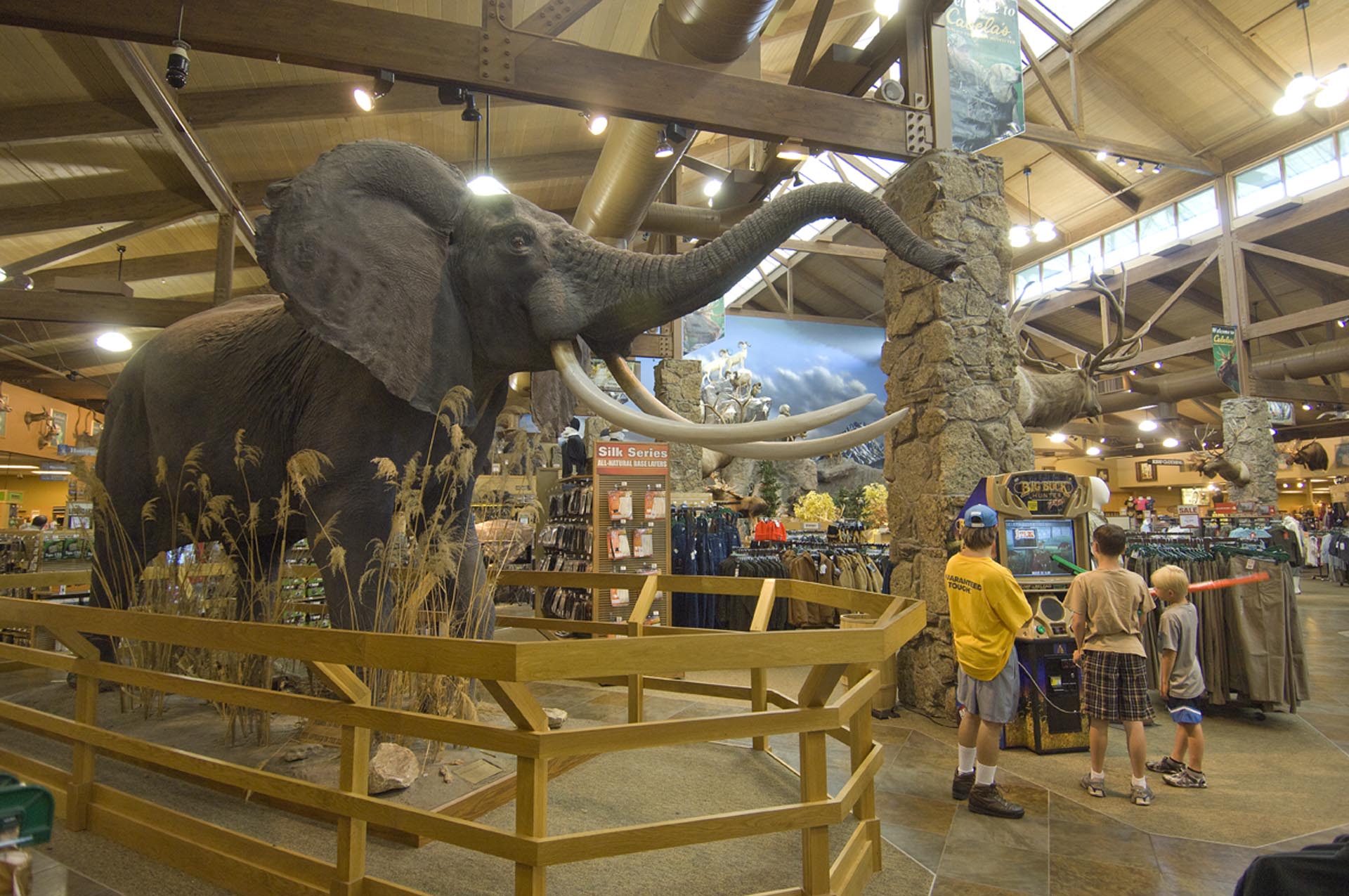 A life-like elephant among other the animal displays with three kids playing a hunting arcade game inside Cabela's in Sidney. 