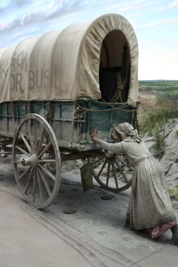 A pioneer display of a settler pushing a covered wagon at The Archway Museum in Kearney.