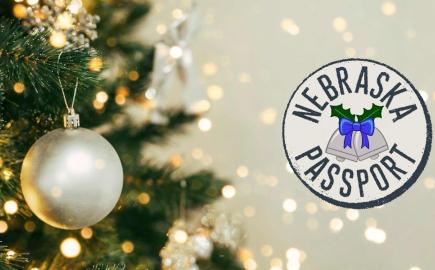 Nebraska holiday passport logo next to a Christmas tree with ornaments.