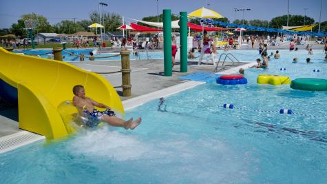 A child riding on an inner tube splashes into the pool at the end of a slide at a water park in Nebraska.